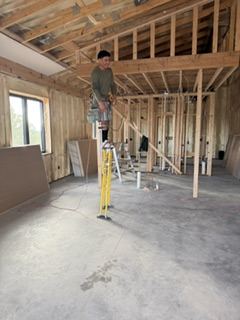 Drywall crew lead reviewing construction plans on a residential job site