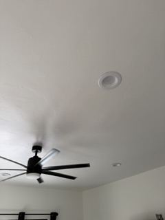 Smooth repaired ceiling around a can light and ceiling fan