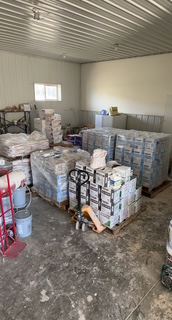 Drywall sheets, mud buckets and taping tools staged in the shop